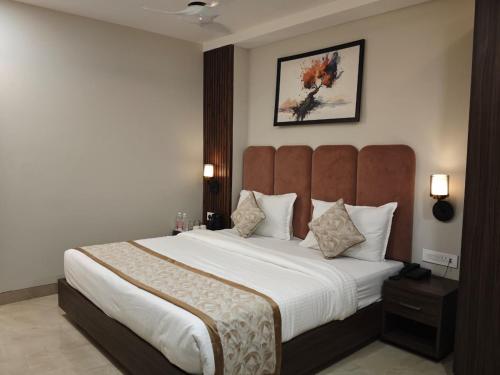 a bedroom with a large bed with a large headboard at Hotel Kaashika in Varanasi