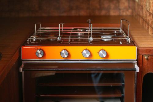 an orange stove top oven sitting in a kitchen at Jahta Engures ostā in Engure