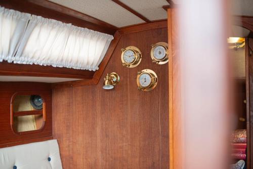 a bunch of clocks on the wall of a boat at Jahta Engures ostā in Engure