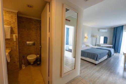a bedroom with a bed and a bathroom with a mirror at Miarosa İncekum Beach in Avsallar