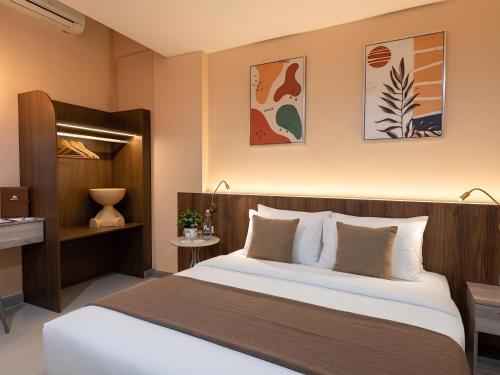 a bedroom with a large bed in a room at เดย์ อินน์ บาย วินด์แฮม ระยอง อู่ตะเภา in Rayong