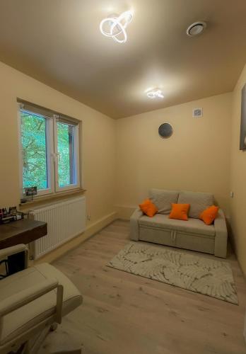 a living room with a couch with orange pillows at Siedlisko Wyżne in Wyżne