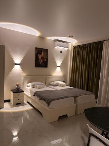 a bedroom with a large bed with lights on it at Mzeonas Apartment in Kobuleti