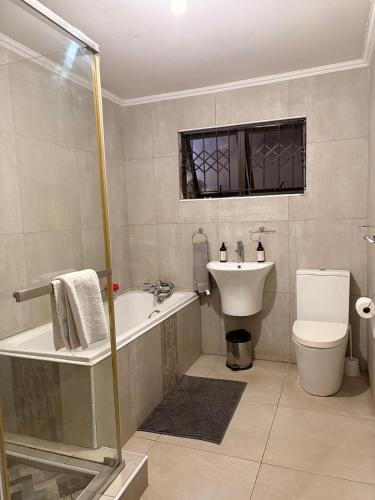 a bathroom with a tub and a toilet and a sink at Local Roots in Pinetown