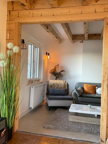 a living room with two couches and a table at Chalet Les Balcons du Risoux in Bellefontaine