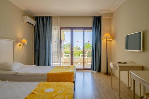 a hotel room with two beds and a balcony at Miarosa İncekum Beach in Avsallar