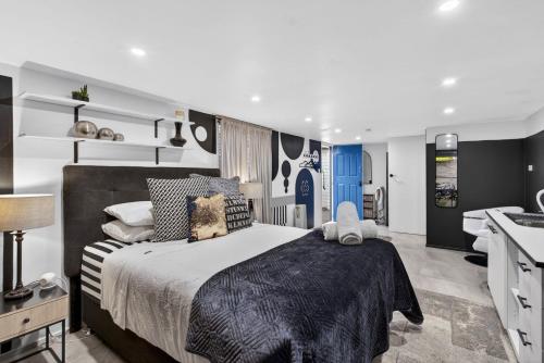 a bedroom with a large bed and a sink at Eleda House Hunter Valley Escape in Cessnock