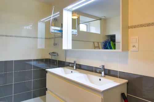 a bathroom with a sink and a mirror at Chez Manie Et Mablot in Créances
