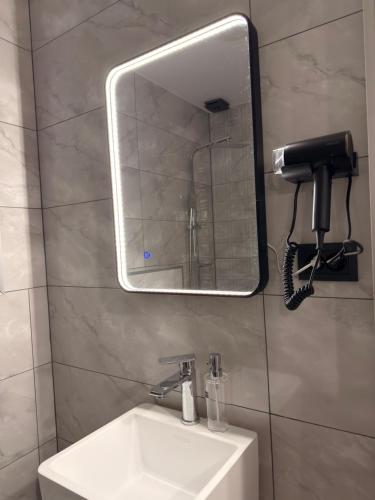 a bathroom with a sink and a mirror and a phone at Mzeonas Apartment in Kobuleti