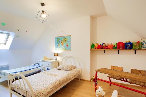 a childs bedroom with a bed and a table at Chez Manie Et Mablot in Créances