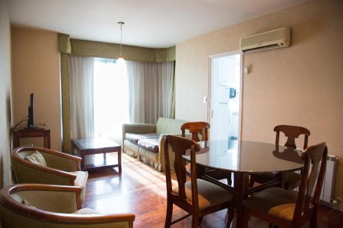un soggiorno con tavolo, sedie e divano di Millenium Mendoza Apartments a Mendoza