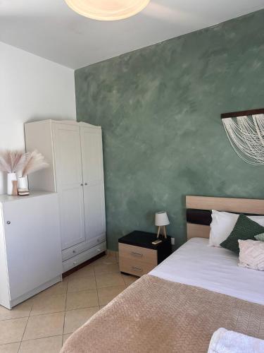 a bedroom with a bed and a green wall at Elia II in Kondoliánika