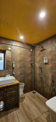 a bathroom with a shower and a sink and a toilet at Hillora Coastal Resort in Arpora
