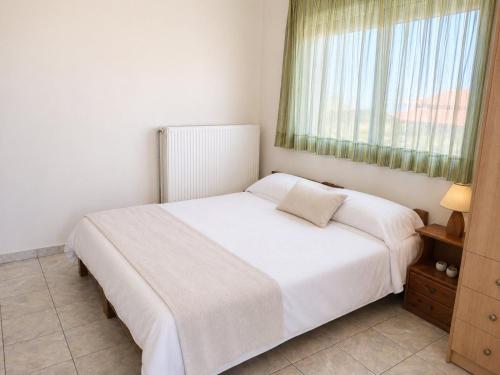 a bedroom with a white bed and a window at MARGIANNA APARTMENTs Seaside Studio in Káto Ássos