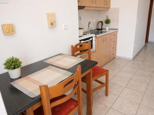 a kitchen with a table and chairs and a stove at MARGIANNA APARTMENTs Seaside Studio in Káto Ássos