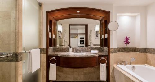 a bathroom with a sink and a large mirror at The Peninsula Manila in Manila