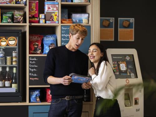 a man and a woman standing in a store at Aparthotel Adagio Access Le Havre Les Docks in Le Havre