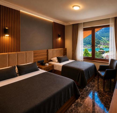 a hotel room with two beds and a window at Sezgin Hotel in Uzungöl