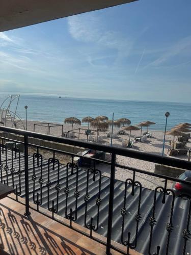 a view of a beach with umbrellas and the ocean at Студиа При Американеца in Pomorie