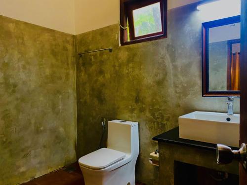 a bathroom with a toilet and a sink at Raniya Villa in Bentota