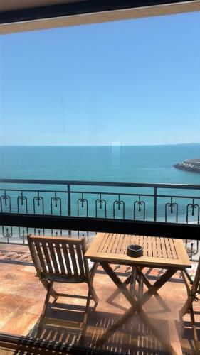 a table and chairs on a balcony with a view of the ocean at Студиа При Американеца in Pomorie