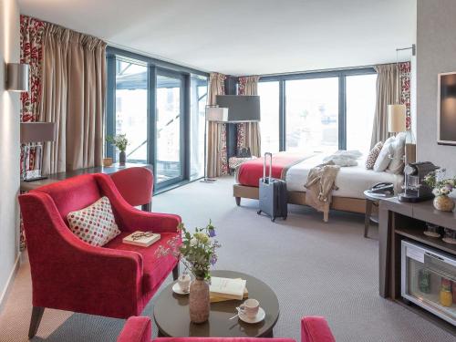 a hotel room with a bed and a living room at Mercure Clermont Ferrand centre Jaude in Clermont-Ferrand