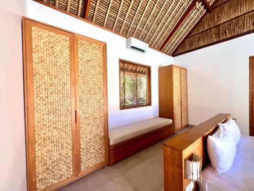 a bedroom with a window and a bed and a window seat at Peninsula Bay Resort in Nusa Dua