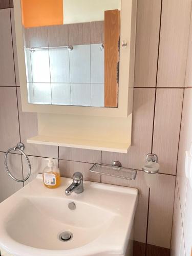 a white sink in a bathroom with a mirror at Villas Kavouri in Kryonéri