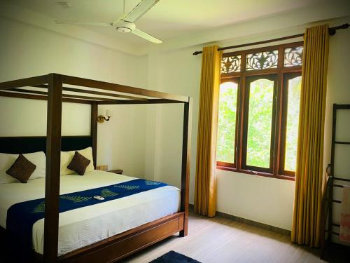 a bedroom with a canopy bed and a window at Raniya Villa in Bentota