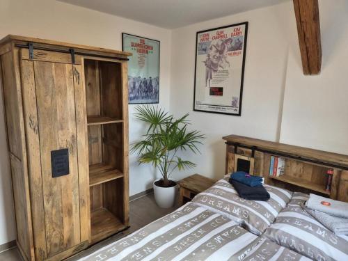 a bedroom with a bed and a wooden cabinet at NEU! Über den Dächern von Mücheln in Mücheln