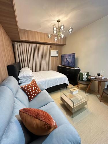 a living room with a blue couch and a bed at JB's Space in Cagayan de Oro