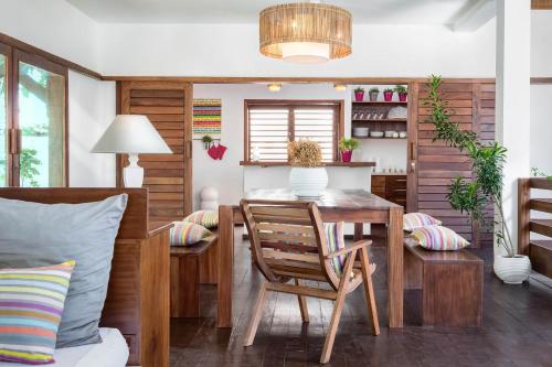 a dining room with a wooden table and chairs at Villa Métisse in Jericoacoara