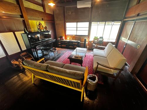 a living room with a couch and chairs in a room at 一棟貸し古民家赤ちゃんから楽しめる文化庁選定重要伝統的建造物 築130年"古民家ゆうなぎ"小松空港から35分 金沢から60分 in Kaga