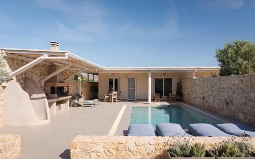 a backyard with a swimming pool and a house at Olive Tree House in Anavyssos