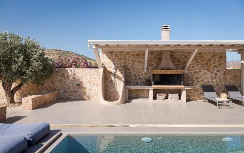 an outdoor patio with a fireplace and a swimming pool at Olive Tree House in Anavyssos