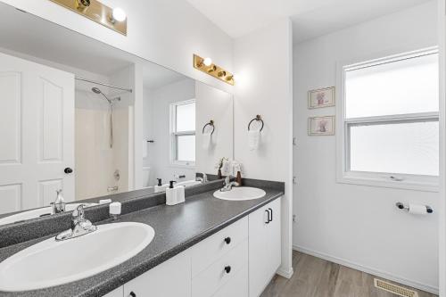 a bathroom with two sinks and a large mirror at KnoxPeace BnB in Kelowna