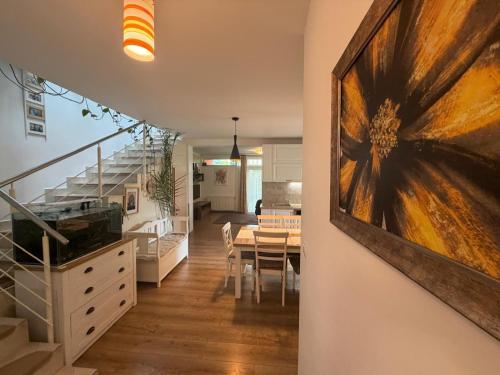 a dining room and kitchen with a large painting on the wall at Harmony Haven - Spacious 4BR House with Free Parking in Cluj-Napoca