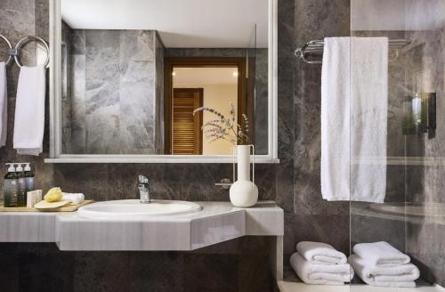 a bathroom with a sink and a mirror at Aquila Rithymna Beach in Adelianos Kampos