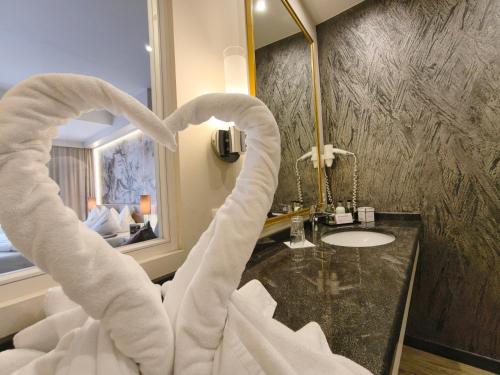a bathroom with a heart shaped towel dispenser next to a sink at Alpen-Herz Romantik & Spa - Adults Only in Ladis