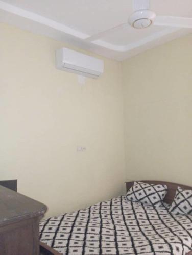 a bedroom with a bed with a ceiling at Hollande House Blm in Ouagadougou