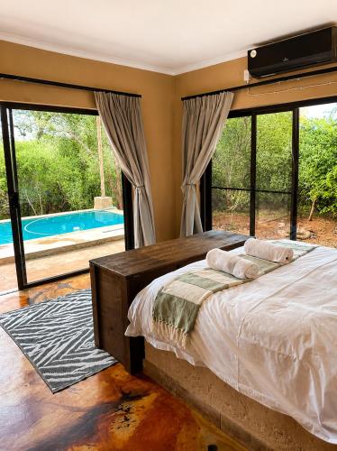 a bedroom with a bed and a large window at Wonderviews Hedgehog in Marloth Park