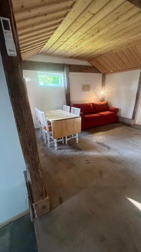 a living room with a red couch and a table at Landskaptsutsikt in Stallarholmen