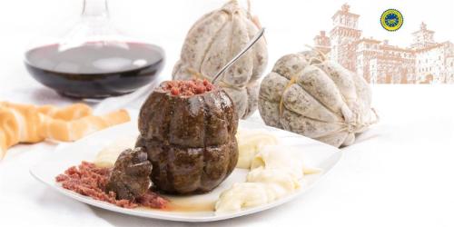 a plate of food with meat and other foods at Palazzo Spada - Attico con terrazza vista fiume in centro in Codigoro