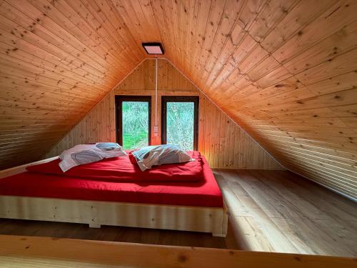 a bed in a wooden room with a large window at Livada Bunicilor in Zamfireşti