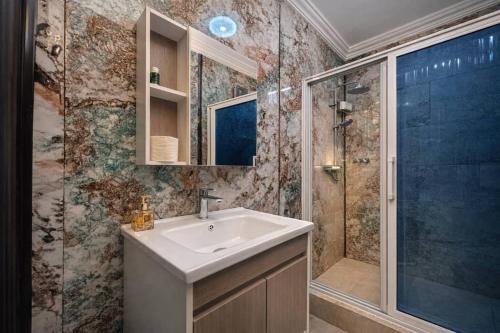 a bathroom with a sink and a shower at Airport Side Hotel in Accra