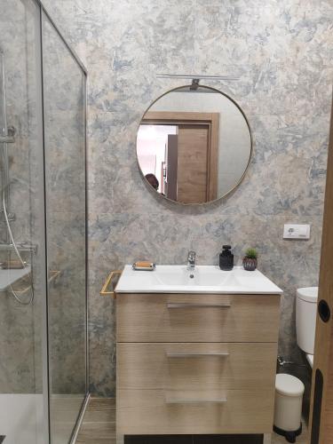 a bathroom with a sink and a mirror at Magariños Apartamentos in Oia