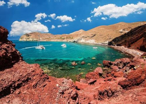 a beach with two boats in the water at Assyr A - Santorini Cozy Cycladic Retreat in Akrotiri