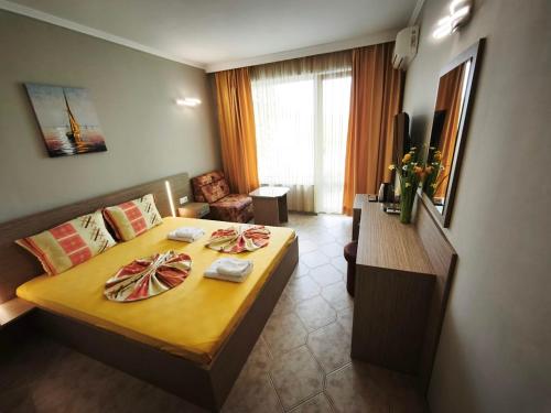 a hotel room with a bed and a table with towels at Guesthouse Kamelia in Ahtopol