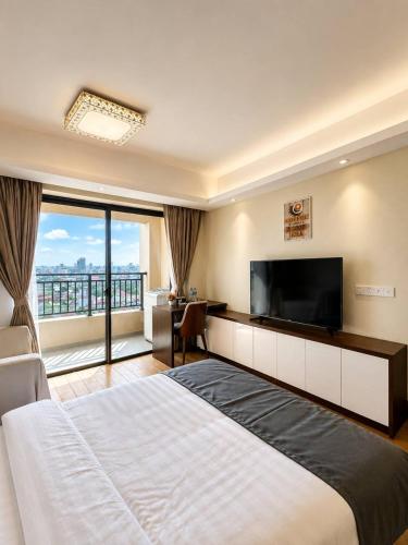 a hotel room with a large bed and a flat screen tv at Tian Yue Hotel in Phnom Penh
