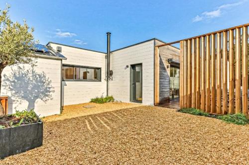 a white house with a wooden facade and a driveway at Villa Boréal with spa in the heart of St Gilles in Saint-Gilles-Croix-de-Vie